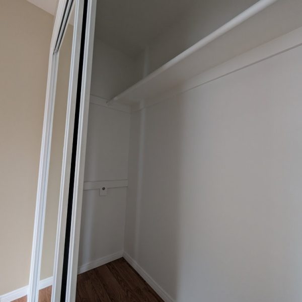 Detailed view of a freshly painted white closet interior and shelving, showing clean lines and full coverage by Paint Daddy.
