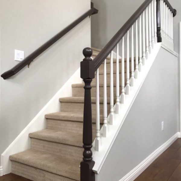 Detailed view of a full interior repaint in Santa Clarita, including neutral gray walls, contrasting dark staircase handrails, white baseboards, and balusters by Paint Daddy