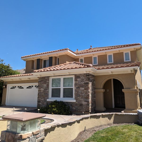 A detailed view of the front entrance of a luxury repaint in Santa Clarita, highlighting the clean trim lines where the paint meets intricate stonework, completed by Paint Daddy.