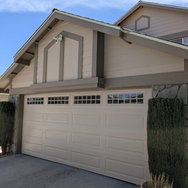 Front view of a home featuring sandy tan siding, cocoa taupe architectural trim, and matching flagstone veneer integration by Paint Daddy.