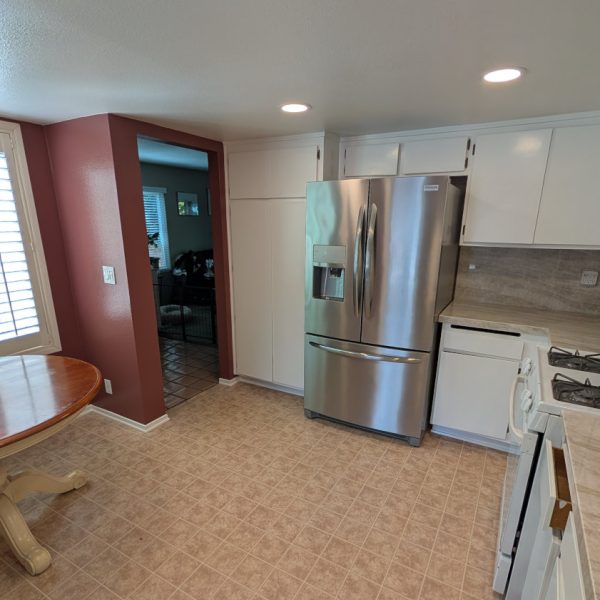 Detailed view of a kitchen pantry and upper cabinets refinished in a clean white semi-gloss, showcasing uniform coverage and smooth texture by Paint Daddy in Santa Clarita.